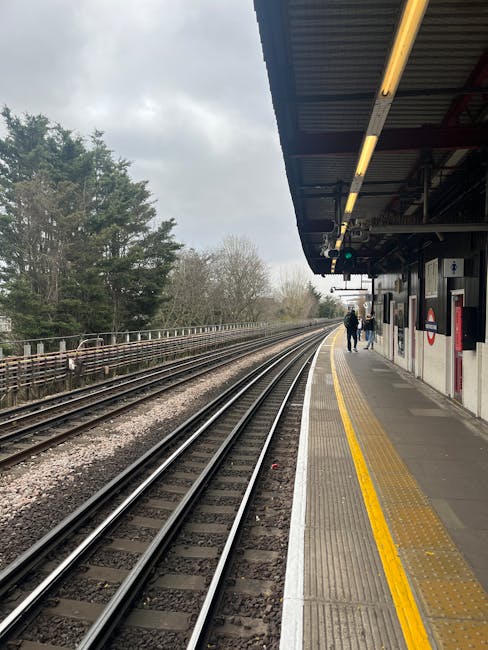 A night-time scene at Perivale tube station platform showing empty space with a row of cardboard boxes and wrapped furniture items placed near the edge of the platform, ready for home relocation or mo